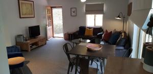 a living room with a couch and a table at Donnybrook Cottages - Hutt River in Clare