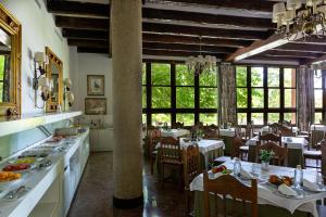 un comedor con mesas y sillas en un restaurante en Parador de Gijón en Gijón