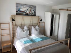 a bedroom with a bed with a painting on the wall at Ferienwohnungostseeblick in Börgerende-Rethwisch