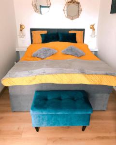 een groot bed met een oranje en blauwe dekbed bij Sunset in Dziwnów