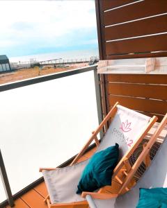 een hangmat op een balkon met uitzicht op het strand bij Sunset in Dziwnów