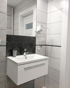 een badkamer met een witte wastafel en een spiegel bij Sunset in Dziwnów