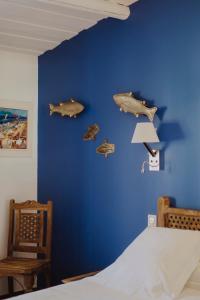 un dormitorio con una pared azul con peces. en Oustau Camarguen Hôtel & Spa en Le Grau-du-Roi