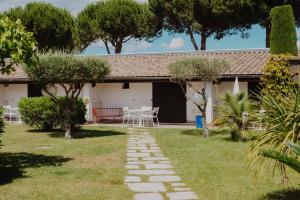 un jardín con un camino de piedra que conduce a una casa en Oustau Camarguen Hôtel & Spa, en Le Grau-du-Roi