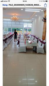 a dining room with white tables and white chairs at Quynh Yen Hotel in Ha Long