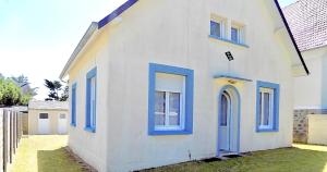 a white house with blue doors and windows at Les Sables d'or in Agon Coutainville