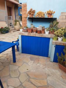 a blue fence with potted plants on a patio at Casa Vacanza Su bonu Acatu in Càbras