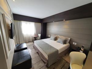 a hotel room with a bed and a window at Class Hotel Piracicaba in Piracicaba