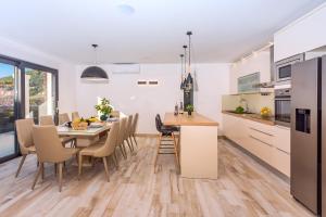 a kitchen and dining room with a table and chairs at Villa Topaz in Dugi Rat