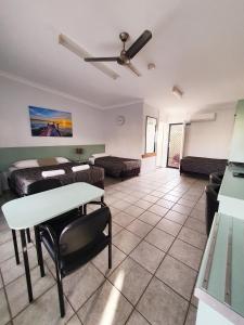 Sala de estar con cama y mesa en Sunseeker Motel, en Hervey Bay