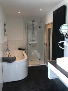 a bathroom with a tub and a shower and a sink at Ostseeperle in Grömitz