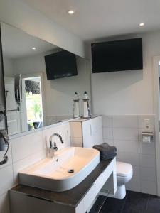 a bathroom with a sink and a toilet at Ostseeperle in Grömitz +10 photos