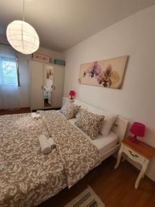 a bedroom with a bed and a couch and a lamp at Apartman Nikolina in Biograd na Moru