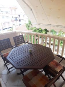 a wooden table and chairs on a balcony at Argiro's Apartment in Iraklitsa