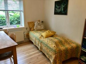a teddy bear sitting on a bed in a bedroom at Frydenlundsvej, Rønne, Bornholm in Rønne