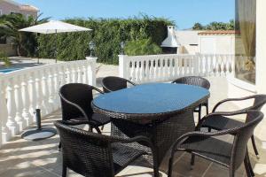 een patio met een tafel en stoelen en een parasol bij Villa Coral Bee - walking distance to Coral Bay Beach in Peyia