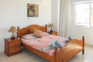 een slaapkamer met een houten bed en 2 nachtkastjes bij Villa Coral Bee - walking distance to Coral Bay Beach in Peyia