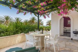 een tafel en stoelen op een patio met roze bloemen bij Bougainvillea House in Crete in Sitia
