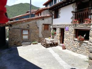 a stone house with a table in front of it at Casas Rurales La Casuca in Ojedo