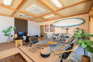 柏崎的住宿－Tabist Odakeya Ryokan Kashiwazaki，一个带椅子的房间和墙上的大型冲浪板
