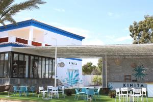 a building with tables and chairs in front of it at Bungalows Mar Menor, paz a orillas del mar in San Javier