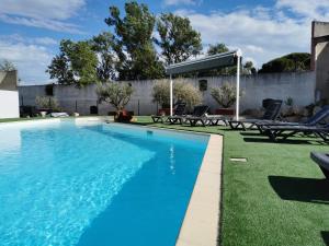 una piscina de agua azul en un patio en Hôtel Le Floreal, en Trèbes