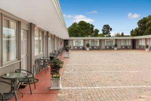a courtyard with tables and chairs and a building at Bendigo McIvor Motor Inn in Bendigo