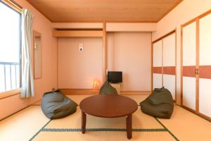 - un salon avec une table et deux chaises dans l'établissement Tabist Odakeya Ryokan Kashiwazaki, à Kashiwazaki