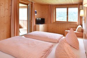 Cette chambre comprend 2 lits et une fenêtre. dans l'établissement Panoramahof Eggele, à Schoppernau