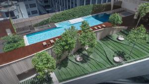 an overhead view of a pool with chairs and trees at Magnolias Ratchadamri Boulevard Serviced Residences in Bangkok