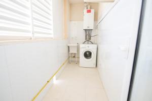 a white laundry room with a washer and dryer at Oros de Malasigeni Bl. III 3ºA in Canyamel
