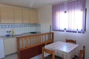 a kitchen with a table and a sink and a window at Apartment Dragica in Sveti Filip i Jakov