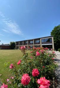 ein Gebäude mit rosa Blumen davor in der Unterkunft Sonnenstrand Hotel in Butjadingen