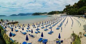 plaża pełna niebieskich leżaków i parasoli w obiekcie Apartment Lerici w mieście San Terenzo