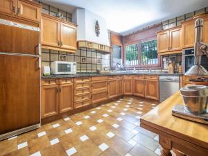 a large kitchen with wooden cabinets and stainless steel appliances at TarracoHomes, Th128 Villa con vistas a la playa la Mora in Tarragona