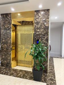 a lobby with a gold door and a potted plant at Ngọc Bích Luxury in Cat Ba