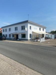 a large white building on the side of a road at Sonnenstrand Hotel in Butjadingen