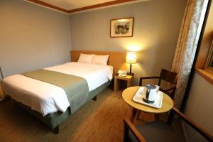une chambre d'hôtel avec un lit et une table dans l'établissement Prime Tourist Hotel, à Busan