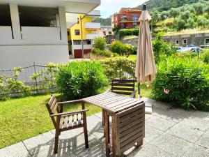 un tavolo con sedie e un ombrellone su un patio di MARIO Apartment with Garden a Levanto