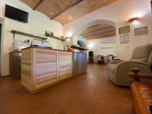 cocina y sala de estar con sofá y mesa en Borgo Bernabei, en Buriano