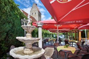 une fontaine dans un patio avec des tables et des chaises dans l'établissement Hotelgasthof zur Sonne, à Bad Gögging