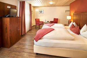 ein Hotelzimmer mit 2 Betten und einem TV in der Unterkunft Hotelgasthof zur Sonne in Bad Gögging