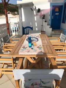 a wooden table with a plate and a drink on it at Traditional House of Diafani in Karpathos