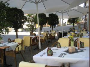 a restaurant with white tables and chairs and umbrellas at Pelikans Krone in Bad Sooden-Allendorf