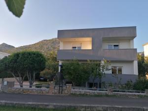 a building with a hill in the background at Apartments Lota in Starigrad-Paklenica