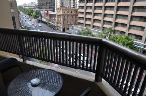 a table on a balcony with a view of a street at Accommodation Sydney - Hyde Park Plaza in Sydney