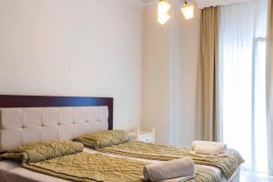 a bedroom with a large bed with a large window at Hotel Zografos in Paralia Katerinis