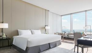 sypialnia z dużym białym łóżkiem i kanapą w obiekcie Niccolo Changsha w mieście Changsha