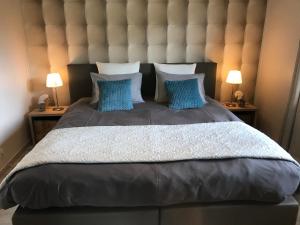 ein großes Bett mit einem großen Kopfteil und zwei Lampen in der Unterkunft Le Chalet de Marguerite in Francorchamps