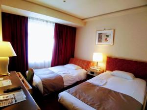Postel nebo postele na pokoji v ubytování Tokyo Grand Hotel